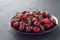 Fresh sweet cherry in black plate on dark stone table. Royalty Free Stock Photo
