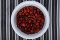Fresh sweet cherry in a white cup on a striped background Royalty Free Stock Photo