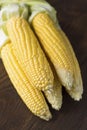 Fresh sweet corn on cobs on dark wooden table. Royalty Free Stock Photo