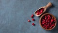 Fresh and sweet cranberries in a wooden bowl on a dark blue wooden background