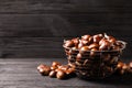 Fresh sweet edible chestnuts in basket on black wooden table. Space for text Royalty Free Stock Photo