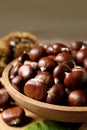 Fresh sweet edible chestnuts in wooden bowl on table, closeup Royalty Free Stock Photo