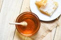 Fresh sweet honey jar with wooden dipper and honeycomb on white plate on wood table background Royalty Free Stock Photo