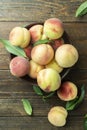 Fresh sweet peaches on the wooden table, selective focus. Fresh ripe peaches with leaves in a bowl Royalty Free Stock Photo