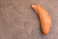 Sweet potato on a brown textured background, empty copy space