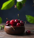 Fresh and sweet red cherries and  in a wooden bowl and green leaves on an old wooden table. Dark photo and rustic style Royalty Free Stock Photo