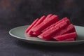 Fresh sweet spanish watermelon sliced on green plate on dark background. Low key close up shot with selective focus Royalty Free Stock Photo