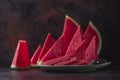 Fresh sweet spanish watermelon sliced on green plate on dark background. Low key close up shot with selective focus Royalty Free Stock Photo