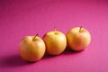 Fresh sweet three apples on pink purple textured background