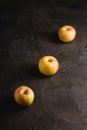 Fresh sweet three apples in row on dark black textured background
