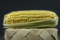 Fresh sweetcorn cob on a tipped wicker basket