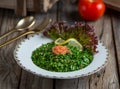 Fresh tabouleh salad or tabbouleh served in a dish isolated on wooden background side view