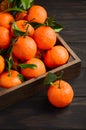 Fresh tangerine clementine with leaves on dark wooden background