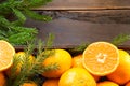 Fresh tangerines in brown box on wooden background with green fir branches. Frame, copy space, holiday and winter fragrance, new Royalty Free Stock Photo