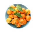 Fresh tangerines in ceramic light blue bowl on white background, top view