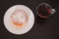 Fresh and tasty bavarian croissant on white plate and a glass of fruit tea over wooden background