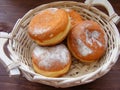 A fresh and tasty Berliner doughnut in bread basket on vintage woodentable