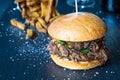 Fresh Tasty Big Chicken Burger with Cheese, Sauce and Fries on Dark Stone Background, Beer on the Background Royalty Free Stock Photo