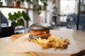 fresh tasty black burger and french fries on wooden table in cafe or restaurant. Royalty Free Stock Photo