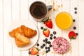 Fresh tasty breakfast with croissant, berries,  donuts, coffee and  orange juice Royalty Free Stock Photo