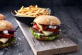 Fresh tasty burger and french fries on wooden table. Royalty Free Stock Photo