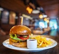 Fresh tasty burger and french fries on wooden table. Royalty Free Stock Photo