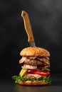 Fresh tasty burger with knife on a black background