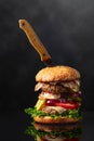 Fresh tasty burger with knife on a black reflective background