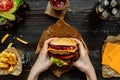 Fresh tasty burgers with french fries, sauce and drink on the wooden table top view Royalty Free Stock Photo