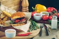 Fresh tasty burgers with french fries, sauce and ingredients on the wooden table top Royalty Free Stock Photo