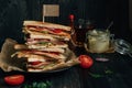 Fresh tasty club sandwich and sauces on the wooden dark table