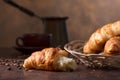 Fresh and tasty croissant and cup of coffee on old copper background Royalty Free Stock Photo