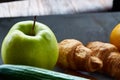 Fresh tasty croissants with apple on dark cutting board, close-up, selective focus Royalty Free Stock Photo