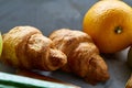 Fresh tasty croissants with apple on dark cutting board, close-up, selective focus Royalty Free Stock Photo