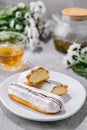 Fresh tasty eclair on white plate and cup of tea Royalty Free Stock Photo