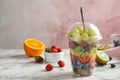 Fresh tasty fruit salad in plastic cup on white marble table Royalty Free Stock Photo