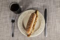 Fresh tasty hot dog with fried onions and fresh lettuce with mustard on a porcelain plate with fork and knife Royalty Free Stock Photo