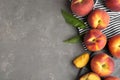 Fresh tasty peaches, fabric and leaves on stone surface, top view with space for text Royalty Free Stock Photo