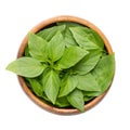 Fresh early-season Thai basil leaves, in wooden bowl, isolated from above Royalty Free Stock Photo