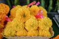 Fresh Thai style flower garlands made of bright yellow marigold with pink ribbon selling on basket in local market Royalty Free Stock Photo