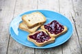 Fresh toasted cereal bread slices with homemade wild berries jam on blue ceramic plate closeup on rustic wooden background Royalty Free Stock Photo