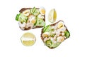 Fresh toasts with shrimp, prawns, quail eggs and cucumber on rye bread. Isolated on white background, Top view. Royalty Free Stock Photo