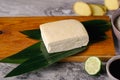 Fresh tofu on bamboo leaves, on a wooden board near soy sauce, rice, ginger and lime. Royalty Free Stock Photo