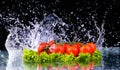 Fresh tomato cherry and green fresh salad with water drop splash on dark background Macro drops of water fall on the red cherry Royalty Free Stock Photo
