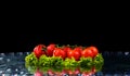 Fresh tomato cherry and green fresh salad with water drop splash on dark background Macro drops of water fall on the red cherry Royalty Free Stock Photo