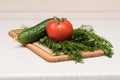 Fresh tomato, cucumber, parsley and dill on the cutting board Royalty Free Stock Photo