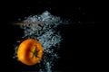 Fresh tomato falling into the water with a big splash on a black background Royalty Free Stock Photo