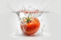 Fresh tomato falling into water with splash isolated on a white background.