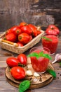 Fresh tomato juice with basil leaves in glasses and ingredients for its preparation Royalty Free Stock Photo