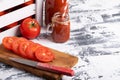 Fresh tomato juice in a glassware. A glass mug of tomato juice. Tomatoes in a box and sliced tomatoes on a wooden board. Space for Royalty Free Stock Photo